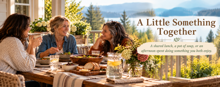 Three women share lunch and conversation on a sunny porch overlooking a lake and mountains, with the article title “A Little Something Together” and subtitle embedded on the right.