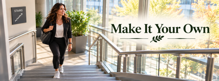 A professional woman in her 50s wearing a blazer, trousers, and sneakers walks up a sunlit office staircase. The wide banner reads “Make It Your Own.”