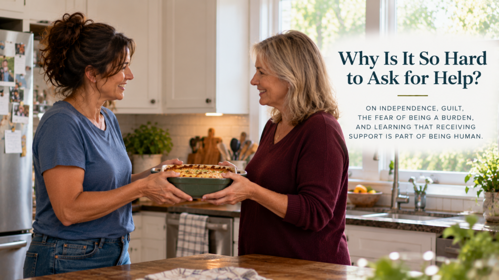 Two women in their fifties stand facing each other in a sunlit kitchen, smiling as they pass a homemade casserole between them. The header reads “Why Is It So Hard to Ask for Help?” with a subtitle about independence, guilt, and accepting support.