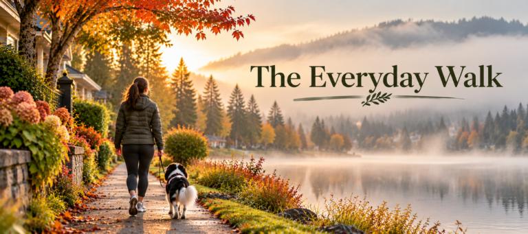 Claire and Oreo, her tricolor Cavalier King Charles Spaniel, walk along a peaceful neighborhood lakeside path on a misty autumn morning. Colorful fall foliage, hydrangeas, and cozy homes frame the scene, with the title “The Everyday Walk” displayed over the lake.
